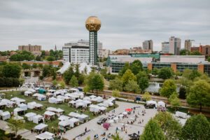 Drone view of knoxville downtown skyline and worlds fair park during dogwood arts festival tents below on grass