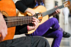 person playing guitar at live music concert in market square knoxville tennessee